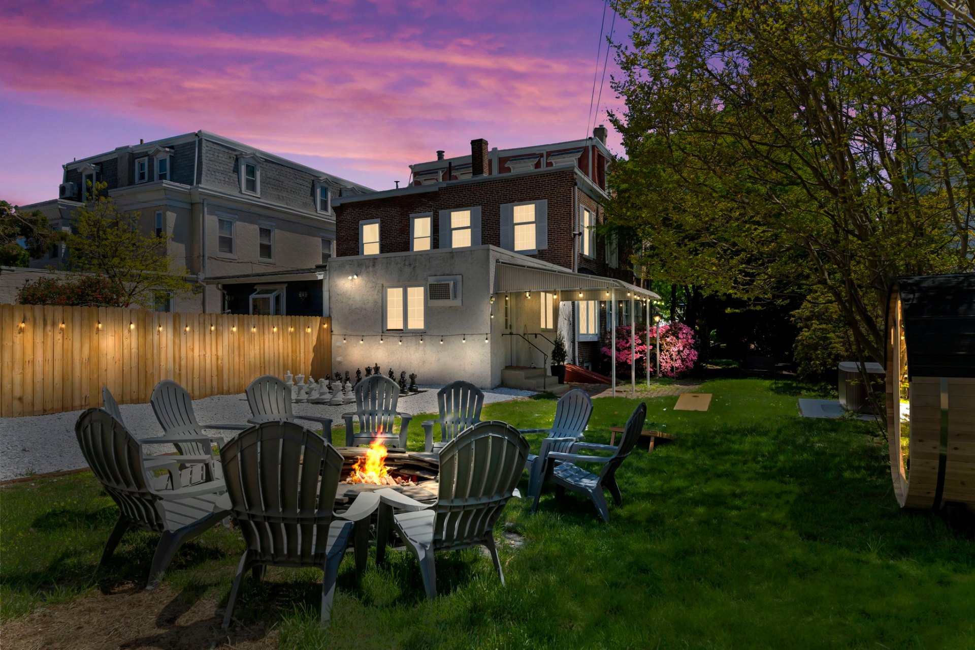 Backyard fire pit at dusk with string lights
