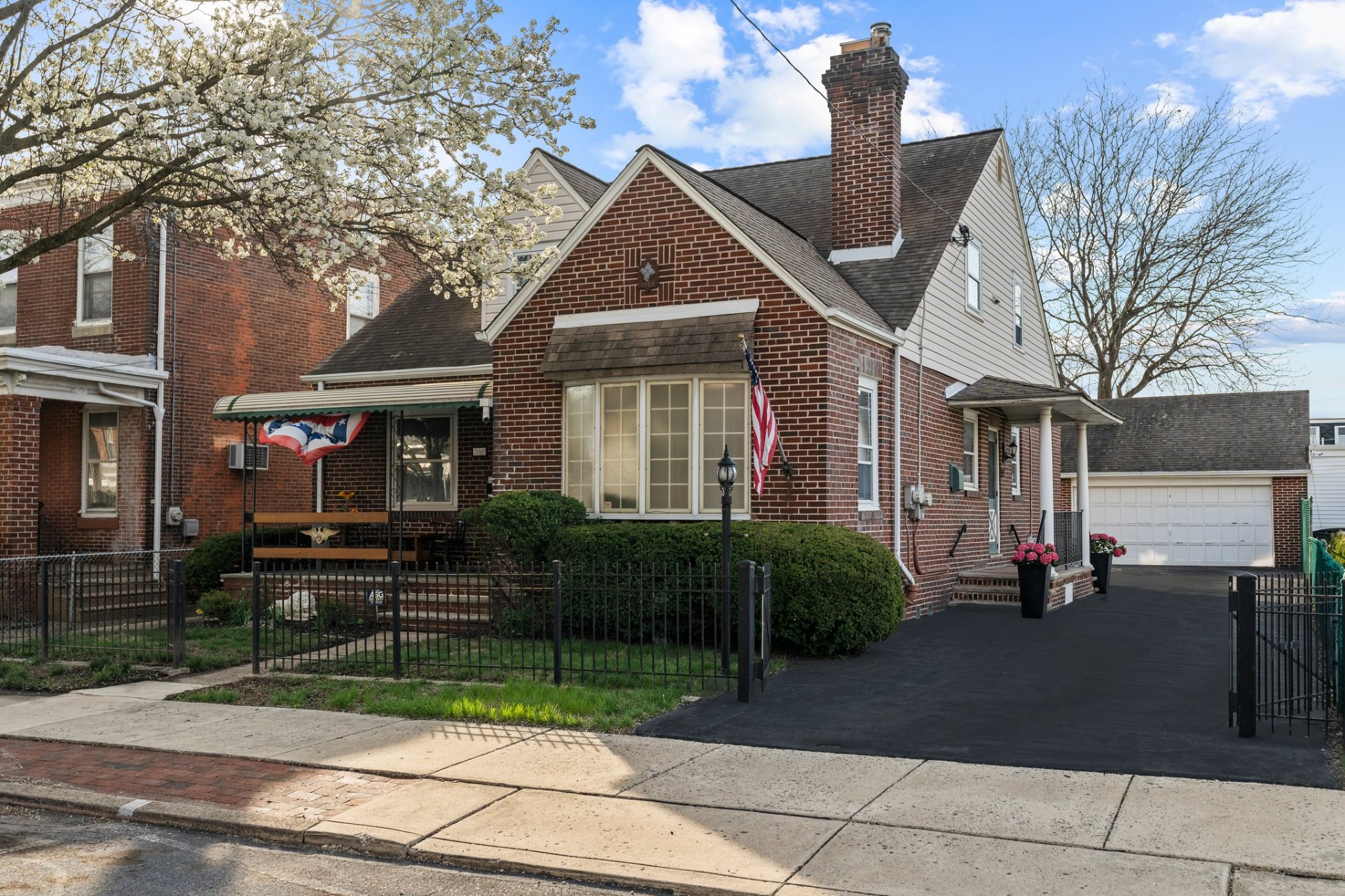 Brick cape-cod home with American flag on the porch