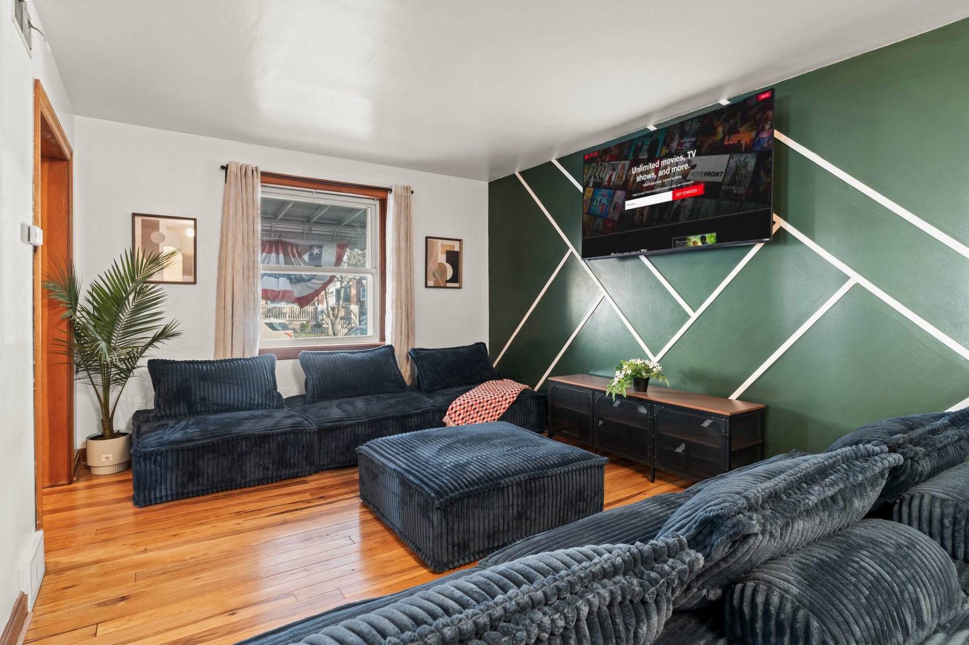 Living room with green accent wall and navy sectional