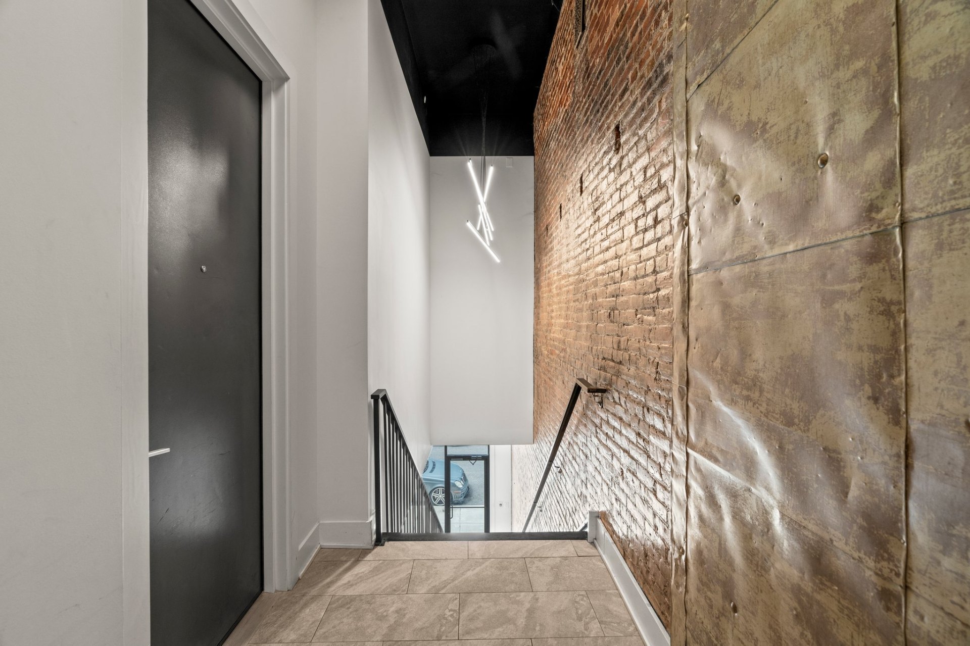 Stairwell with exposed brick and pressed-metal wall