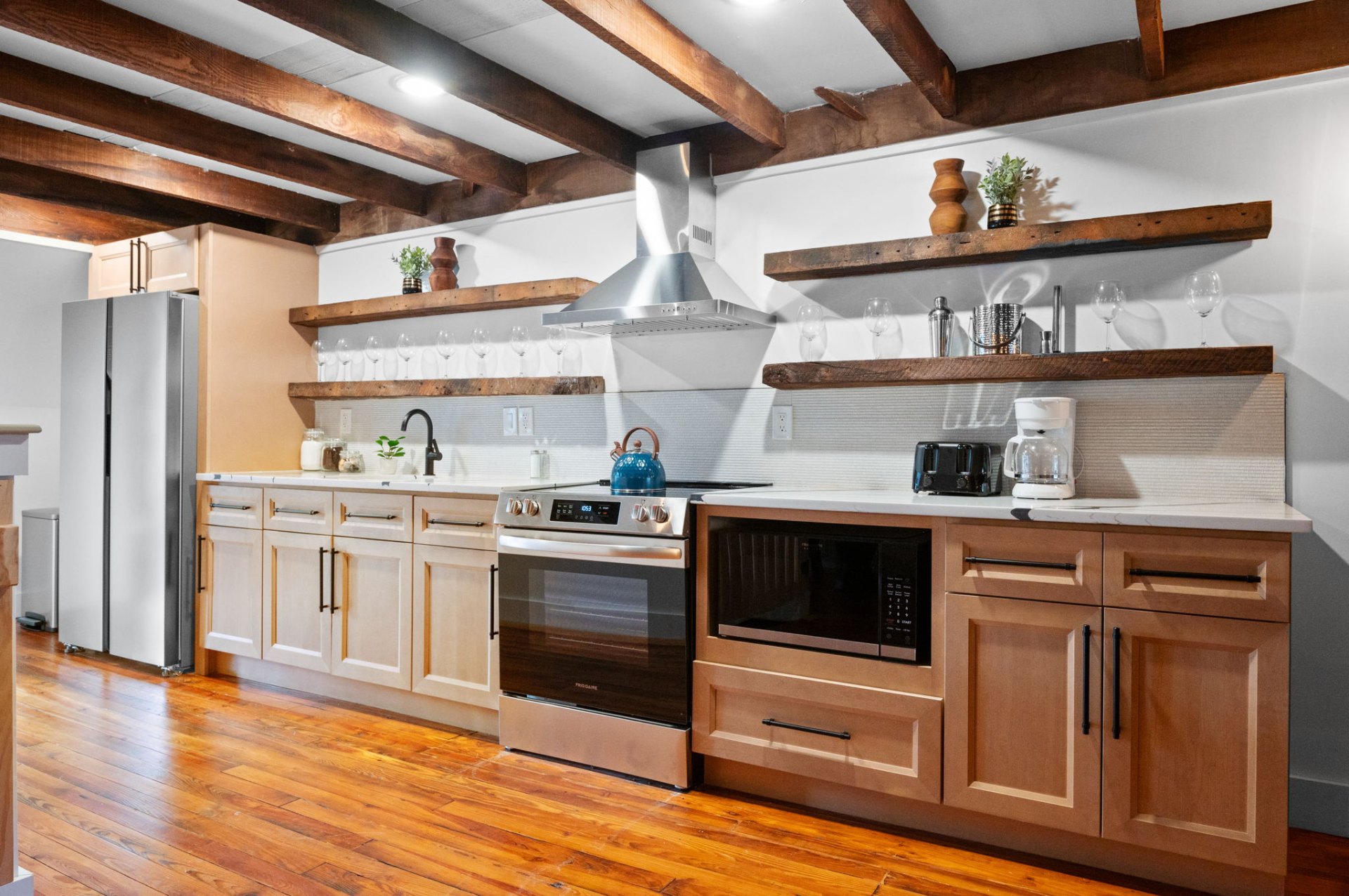 Kitchen with reclaimed wood shelving and exposed beams